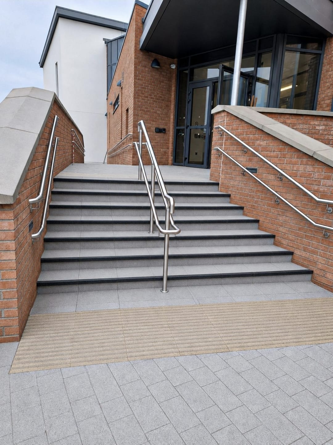 Polished granite entrance steps with stainless handrails