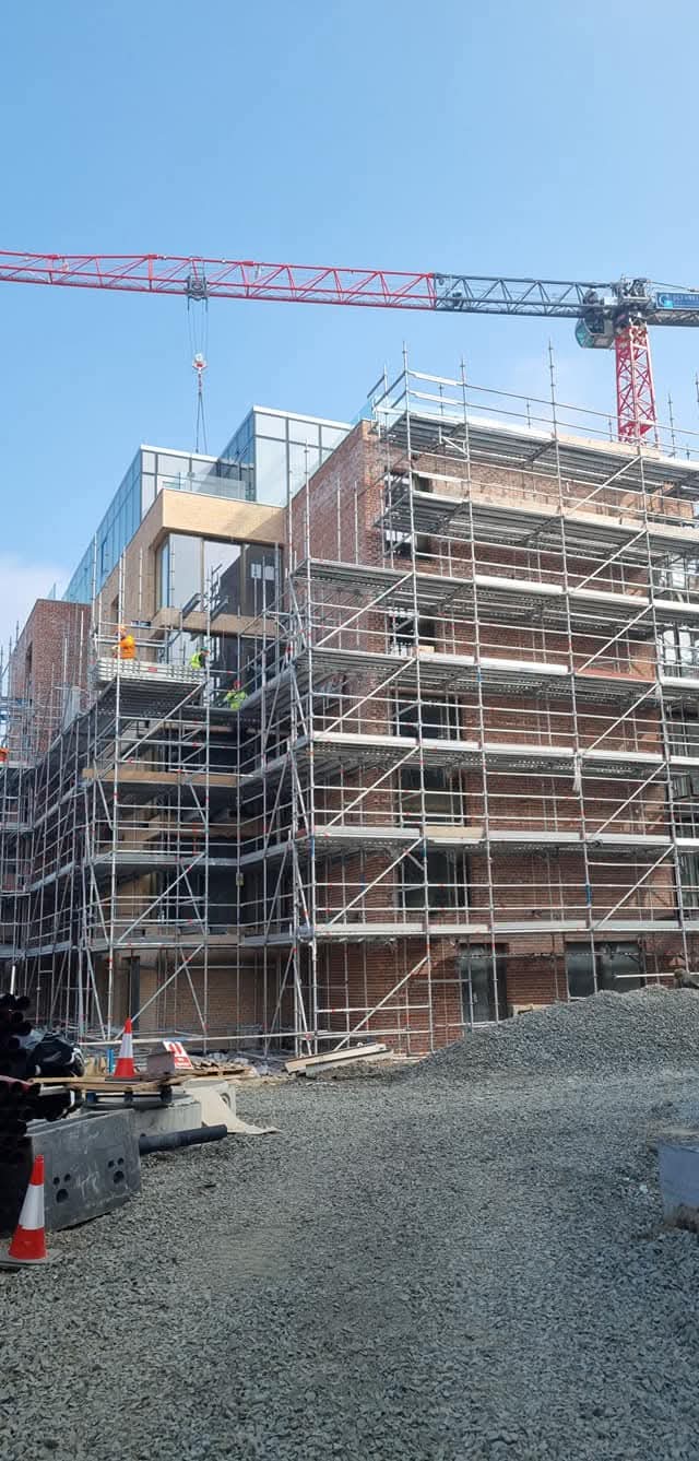 Major apartment block in scaffold with red tower crane
